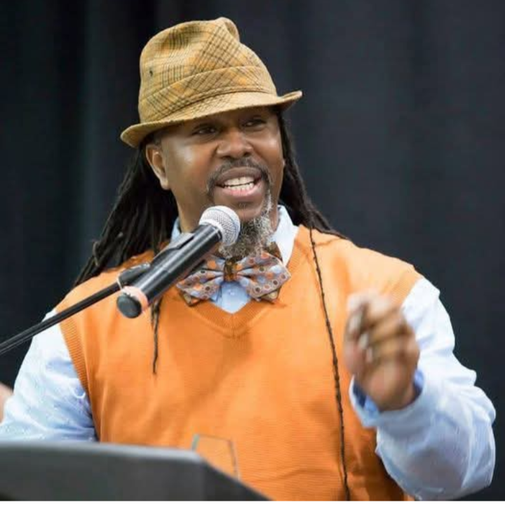 Rodney Alamo Brown speaking at a microphone